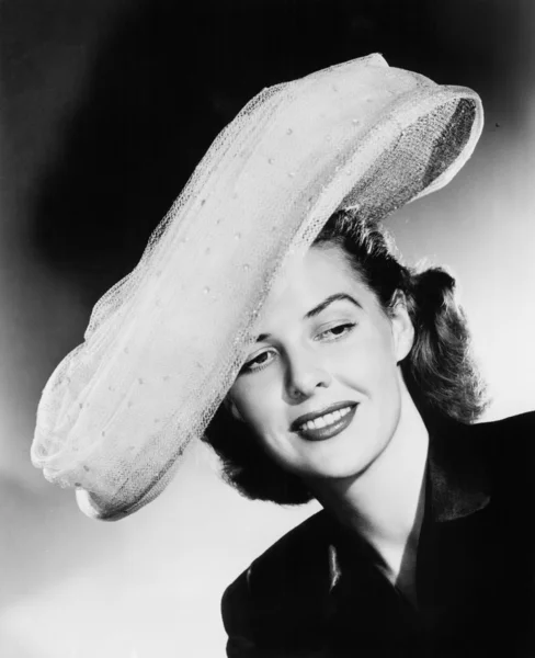 Jonge vrouw met een grote witte hoed — Stockfoto