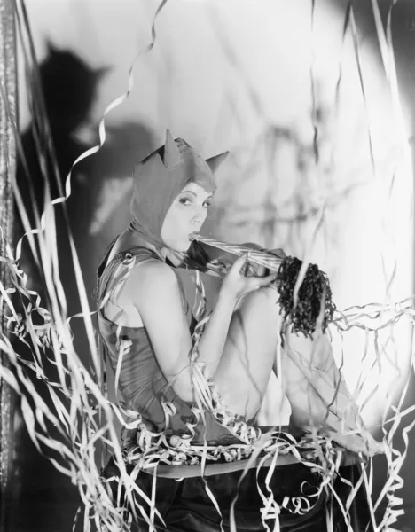 Egy fél ördög, egy fiatal nő fúj saját kürt — Stock Fotó