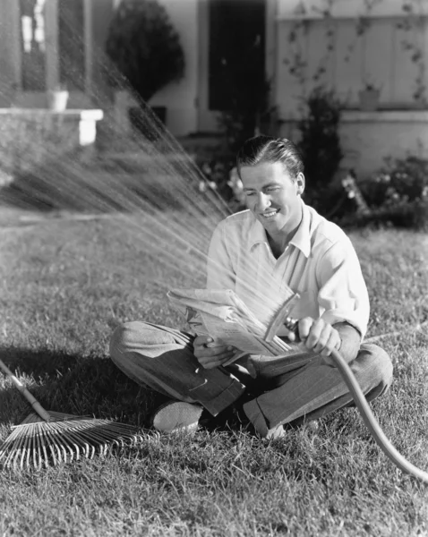 浇水草和阅读的人 — 图库照片