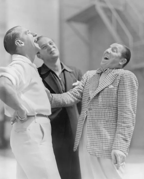 Drie mannen permanent samen en lachen — Stockfoto