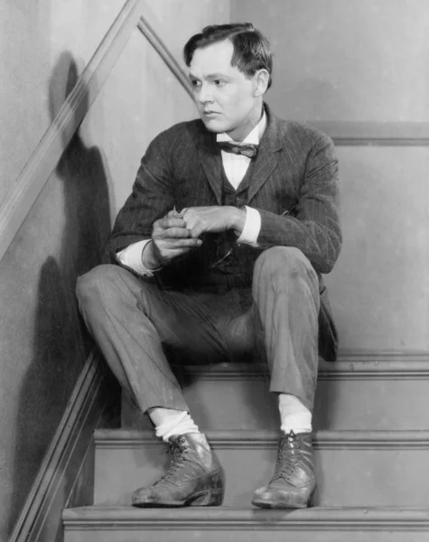 Mann sitzt auf Treppe und schaut ängstlich — Stockfoto