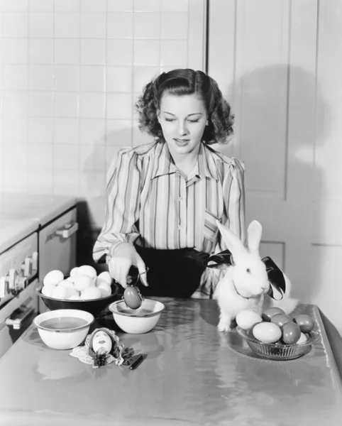 Mujer joven en su cocina para colorear huevos de Pascua — Foto de Stock