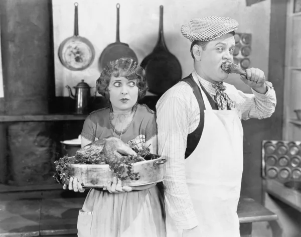Ζευγάρι στέκεται μαζί σε μια κουζίνα με ένα μαγειρεμένο γαλοπούλα — Φωτογραφία Αρχείου