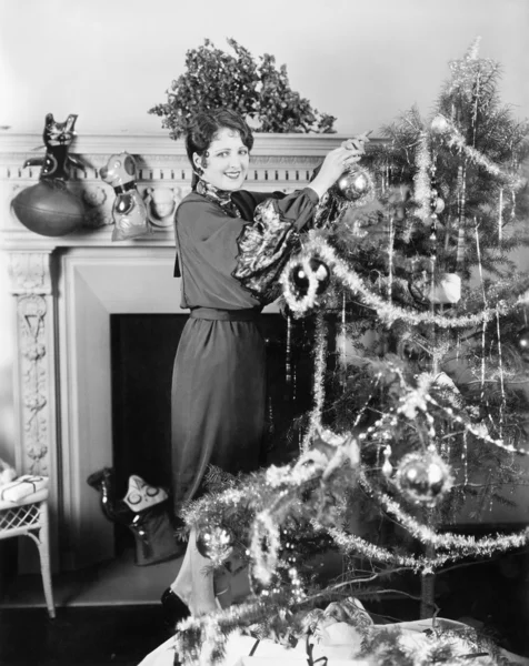 Νεαρή γυναίκα διακόσμησης ενός χριστουγεννιάτικου δέντρου — Φωτογραφία Αρχείου