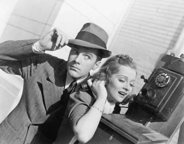 Homme et femme écoutent sur un téléphone extérieur — Photo