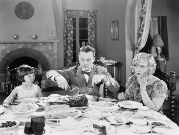 Familia de tres sentados juntos cenando — Foto de Stock