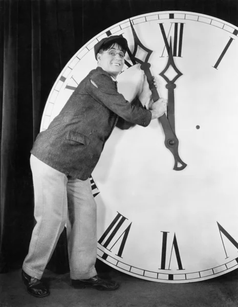 Hombre estableciendo el tiempo en un gran reloj — Foto de Stock