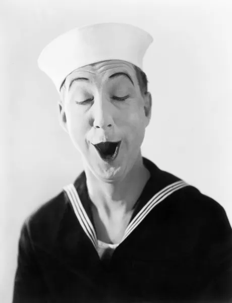 Homme en chapeau de marin et uniforme faisant un visage pantomime stupide — Photo