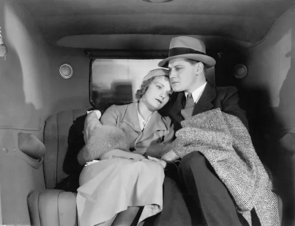 Casal sentado juntos no banco de trás de um carro — Fotografia de Stock
