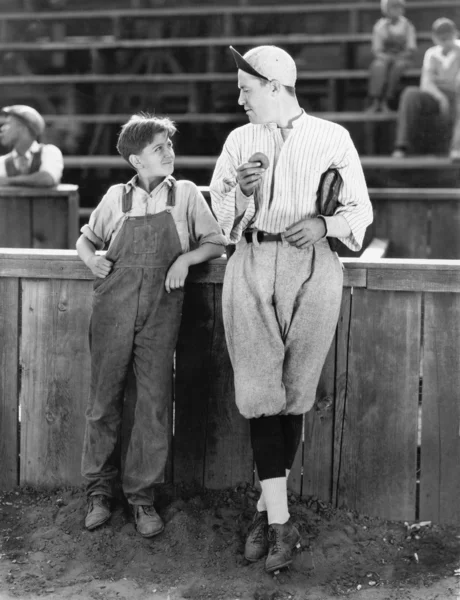 Отец и сын стоят вместе на бейсбольном поле — стоковое фото