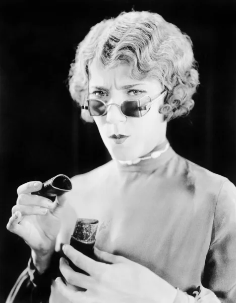 Ung kvinna med ovanliga glasögon håller en öppen kartong — Stockfoto