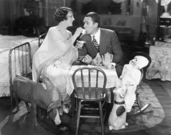 Couple assis sur une table jouet prenant le thé ensemble — Photo