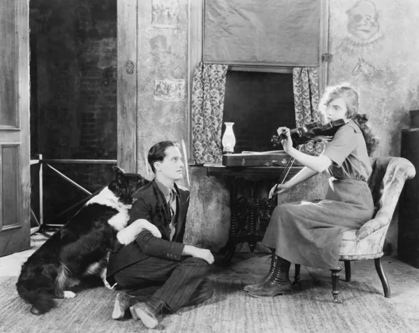 Mulher tocando violino para seu namorado e cachorro — Fotografia de Stock