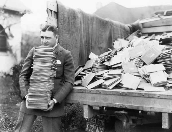 Człowiek rozładowują ciężarówkę pełną listów — Zdjęcie stockowe