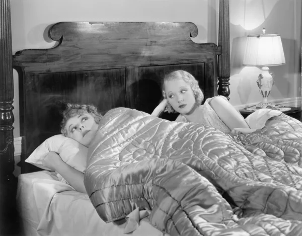 Iki kadın bir battaniyenin altında yatakta birlikte — Stok fotoğraf
