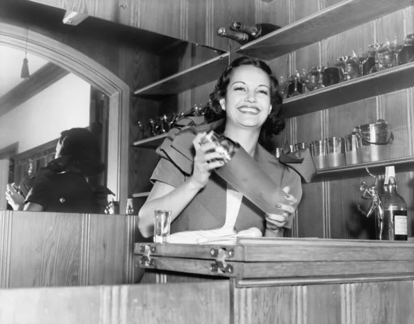 Junge Frau mit einem Shaker in einer Bar — Stockfoto