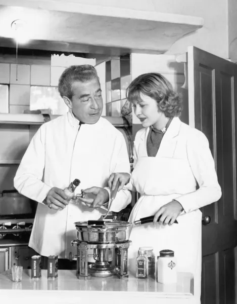 Pareja juntos en la cocina preparando una fondue —  Fotos de Stock