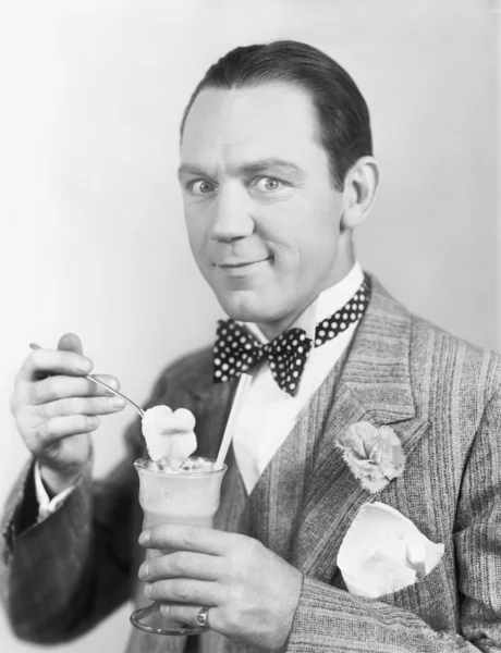 Mann isst ein Eis aus einem Glas mit Strohhalm — Stockfoto