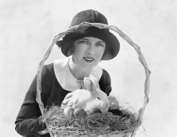 Genç kadın bir Paskalya sepeti ve tavşan — Stok fotoğraf
