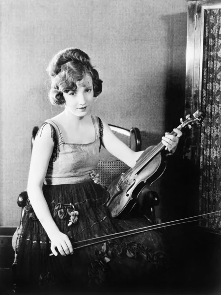 若い女性の椅子に座って、彼女のバイオリンを保持 — ストック写真
