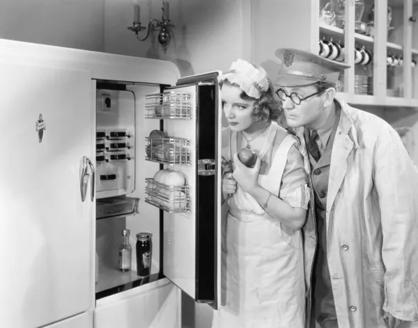 Мужчина и женщина стоят перед холодильником — стоковое фото