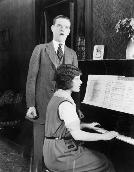 Άνθρωπος, τραγουδώντας και γυναίκα που παίζει πιάνο — Φωτογραφία Αρχείου