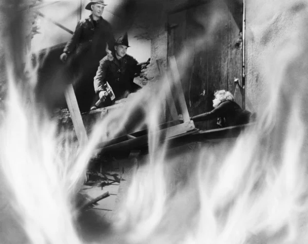 Dois bombeiros resgatando uma mulher — Fotografia de Stock