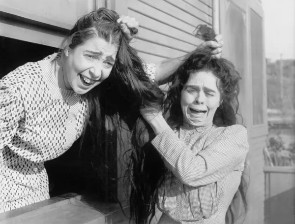 Två kvinnor slåss och dra varandras hår — Stockfoto