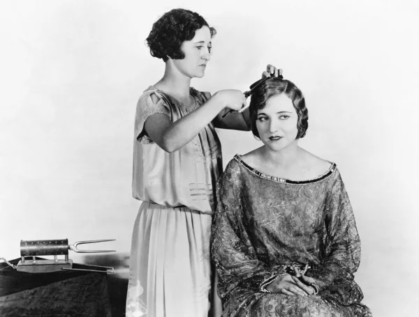 One woman doing another woman's hair — Stock Photo, Image