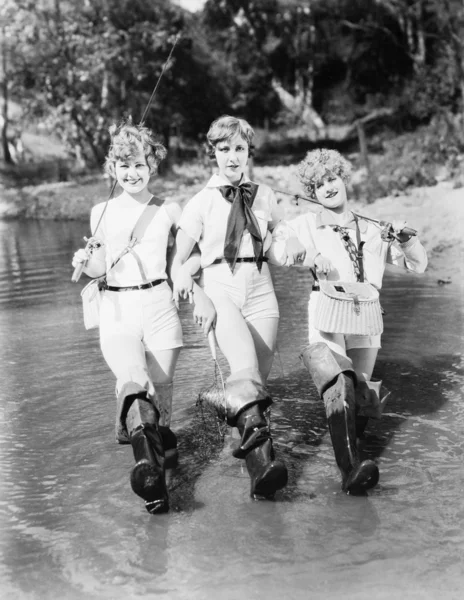 Τρεις γυναίκα που περπατά με καλάμια ψαρέματος, μέσα από ένα ρεύμα — Φωτογραφία Αρχείου