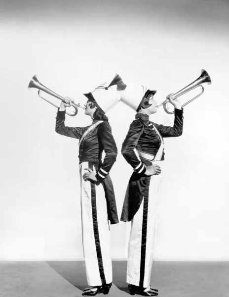 Dos mujeres en uniforme de soldado de juguete con trompetas — Foto de Stock