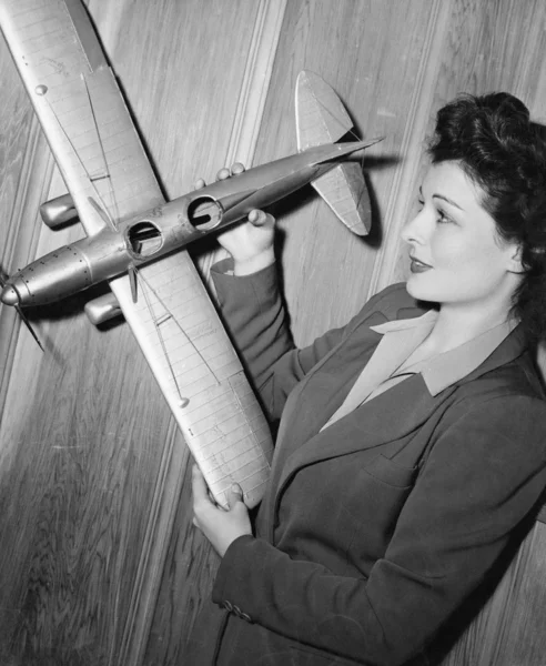 Молодая женщина держит модель самолета — стоковое фото