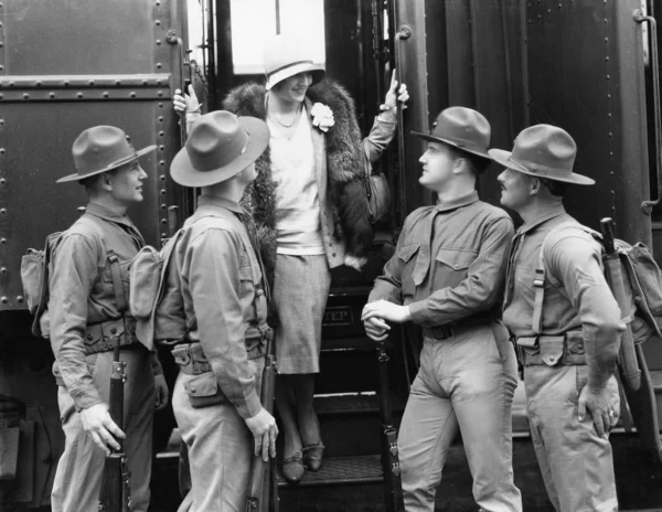 女人正在迎接由四名士兵 — 图库照片