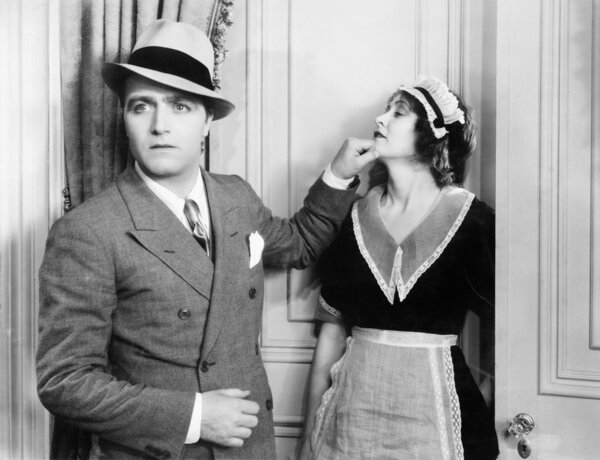 Man pinching the chin of a housekeeper