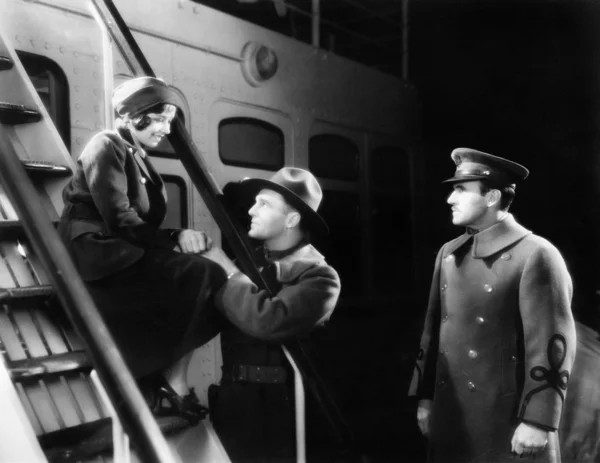 Två män prata med en ung kvinna sitter på fartygets steg — Stockfoto