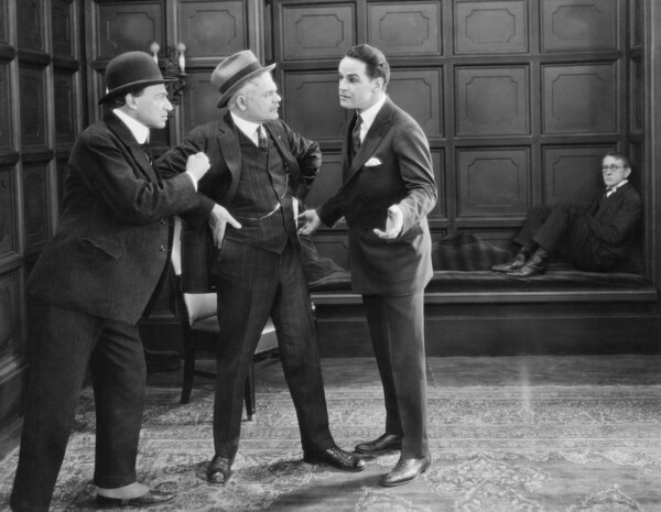 Three men standing together arguing