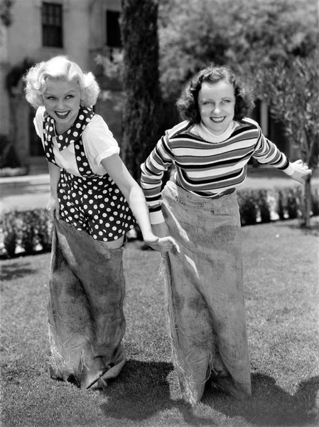 Duas mulheres jogando um jogo de corrida saco de batata — Fotografia de Stock
