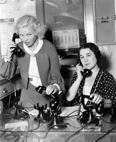 Δύο γυναίκες που εργάζονται σε μια τράπεζα τηλέφωνο — Φωτογραφία Αρχείου