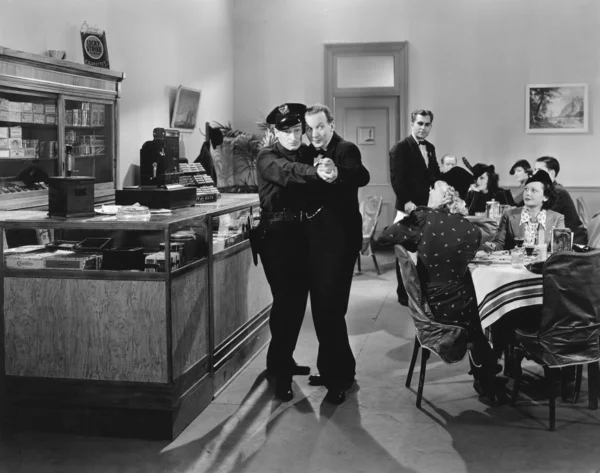 Polizist und ein Mann tanzen in einem Restaurant einen Tango — Stockfoto
