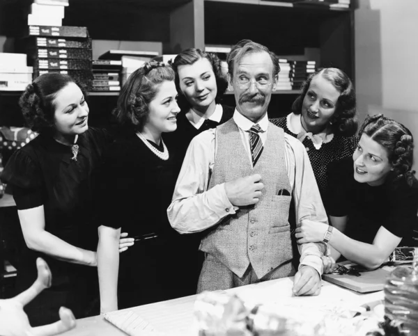 Five young women gathering around a salesman in a store — Stock Photo, Image