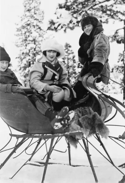 Three women sitting in a sled — Stock Photo, Image