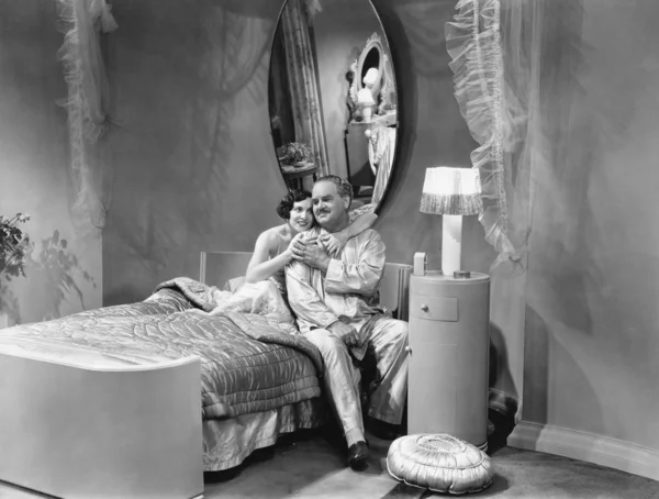 Mann und Frau umarmen sich auf einem Bett — Stockfoto