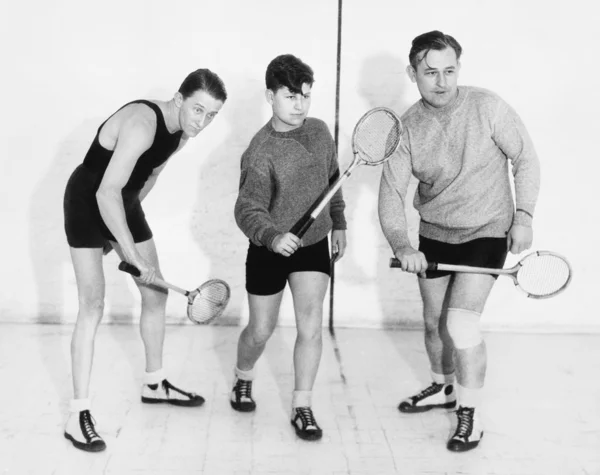 Tři muži hraje squash. — Stock fotografie