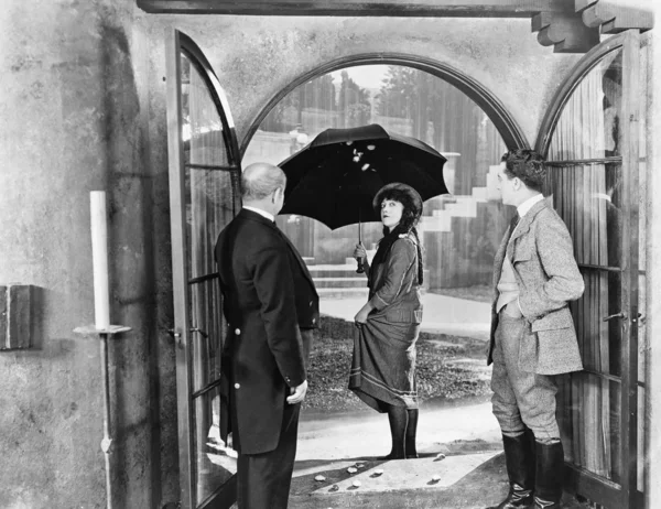 Mladá žena opouští dům s deštníkem chodit v dešti — Stock fotografie