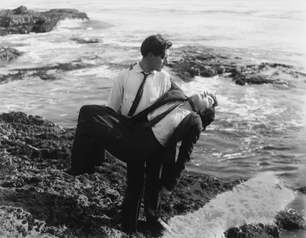 El hombre sacando a un hombre muerto del océano —  Fotos de Stock