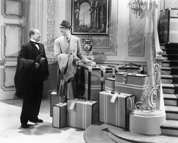 Dwóch mężczyzn stojących na korytarzu z wielu walizki — Zdjęcie stockowe