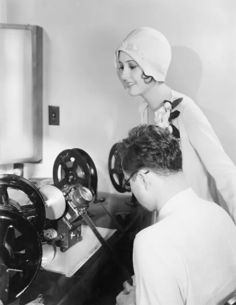 Mulher em uma máquina de edição com um editor revisando filme — Fotografia de Stock