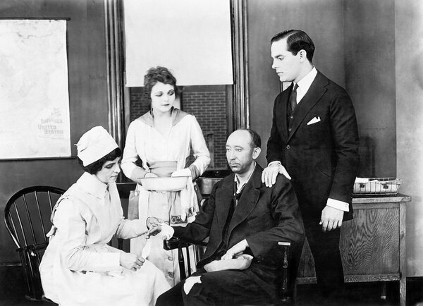 Пациента и двух медсестер, сопровождающих его, и друга, утешающего его
