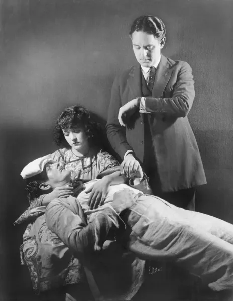 Il dottore prende il polso di un uomo malato — Foto Stock
