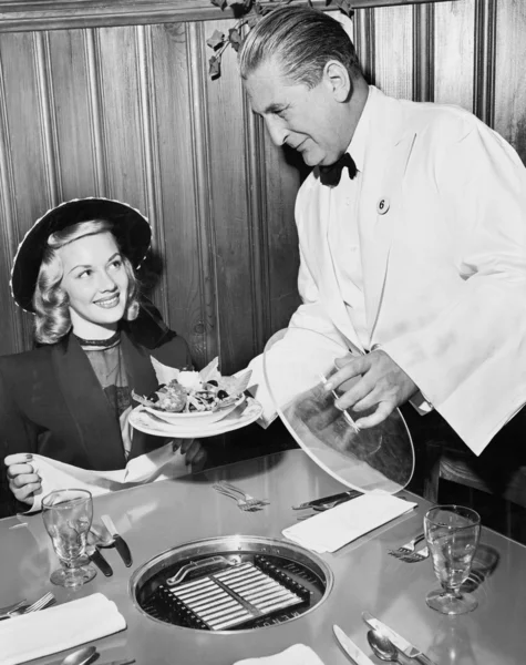 Garson bir kadına, bir restoranda yemek servisi — Stok fotoğraf